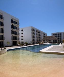 Una gran piscina frente a unos edificios. en Departamento Comodo con Alberca a 10min de la Playa, en Mezcales