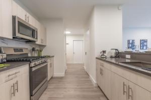 a kitchen with stainless steel appliances and wooden floors at Opulence in Olive with Free Parking, 2 BR 2 baths Suite, 5 beds and Sleeps 8 in Orange