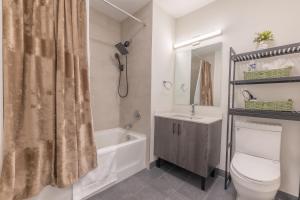 a bathroom with a toilet and a sink and a tub at Opulence in Olive with Free Parking, 2 BR 2 baths Suite, 5 beds and Sleeps 8 in Orange
