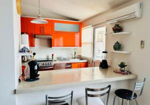a kitchen with orange cabinets and a counter top at Departamento para Renta en Querétaro in Mendiola