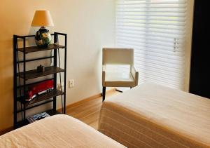 a bedroom with a bed and a chair next to a window at Departamento para Renta en Querétaro in Mendiola +10 photos