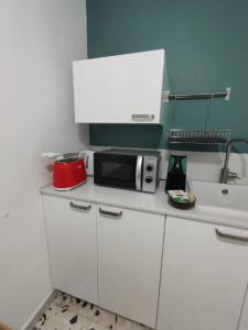 a white kitchen with a microwave and a sink at Gli Amici di Filippo in Agira +19 photos