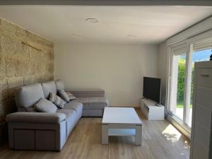 a living room with a couch and a table at Mini casa en Vigo-Playa 1 dormitorio in Vigo