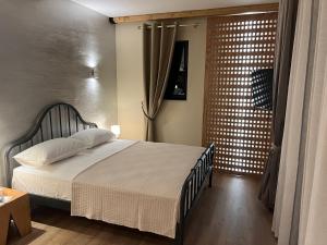 a bedroom with a bed and a sliding glass door at The Poet's House in Himare