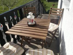 a wooden table and two chairs on a balcony at Apartment Rosandić in Smoljanac