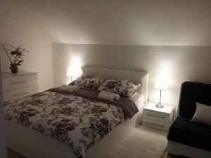 a bedroom with a bed and two night stands and two lamps at Apartment Rosandić in Smoljanac