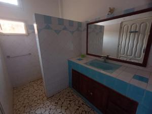 a bathroom with a sink and a mirror at Blue House in Saly Portudal