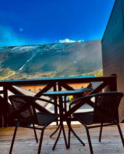 a table and chairs on a balcony with a view at Signegarden in Skjåk