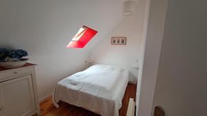 a small room with a bed and a red light at Chez Édouard et Aline classé 2 étoiles in Ploubazlanec