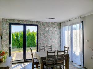 a dining room with a table and chairs and a large window at Villa Anna in Międzywodzie