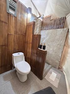 a bathroom with a toilet and wooden walls at Bambuk Bio Dome Uvita beach front in Uvita