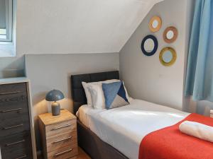 OtterbourneにあるPiping House 4bedroomのベッドとドレッサーのある小さな寝室