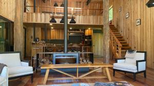a living room with a tv and a table and chairs at Lodge El Remanso, Patagonia Chile in Llanada Grande