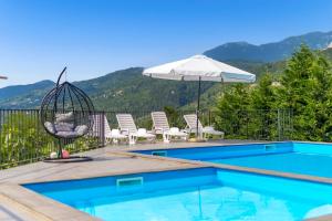een zwembad met stoelen, een schommel en een parasol bij Villa Alternus-apartman Dora in Ičići