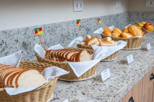 a bunch of baskets of bread on a counter at Hotel Suárez Campo Bom in Campo Bom