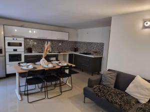 a kitchen and living room with a table and a couch at Séjour à Paris in Bezons