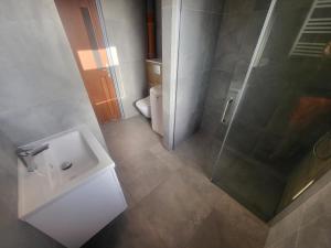 a bathroom with a toilet and a sink and a shower at Pokoje Gościnne Grzybowo in Grzybowo