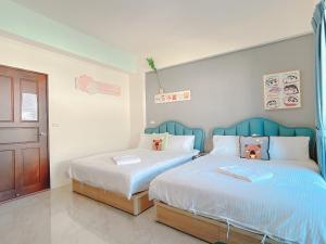 a bedroom with two beds with stuffed animals on them at Happiness blossoms Homestay in Wujie