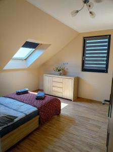 a attic bedroom with a bed and a window at Villa Anna in Międzywodzie