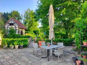 a patio with a table and an umbrella at BnB Het Geluk van Limburg in Mechelen