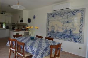 a dining room with a table and a painting on the wall at Villa Marquês in Vila Nova da Barquinha