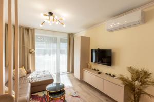 un soggiorno con un divano e una TV di Sunset Resort 003 Jacuzzi a Fonyód
