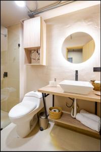 a bathroom with a toilet and a sink and a mirror at Casa Mitho in Bogotá +59 photos