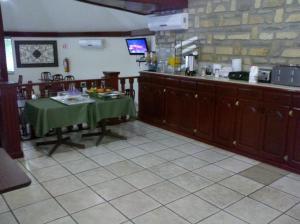 a kitchen with a table and a counter in a restaurant at Palms Hotel in Ciudad Acuña