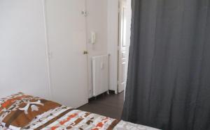 a room with a bed and a window with a curtain at Studio Port Rhu Douarnenez in Douarnenez