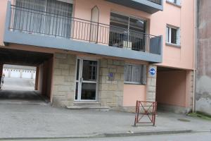 un edificio rosa con balcón y una señal delante de él en Studio Port Rhu Douarnenez, en Douarnenez