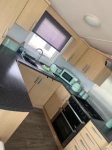 vista sul soffitto di una cucina con armadi in legno di 3 bed deluxe Golden Palm ML47 sleeps 8 a Chapel Saint Leonards