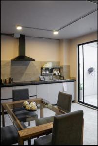 a kitchen with a glass table and chairs in a room at Casa Mitho in Bogotá