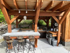 an outdoor kitchen with a counter and stools at Garden Bay Hideaway - Glamping & RV in Garden Bay