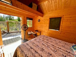 a bedroom with a bed in a wooden cabin at Garden Bay Hideaway - Glamping & RV in Garden Bay