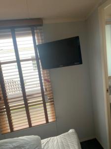 una TV a schermo piatto su un muro accanto a una finestra di 3 bed deluxe Golden Palm ML47 sleeps 8 a Chapel Saint Leonards