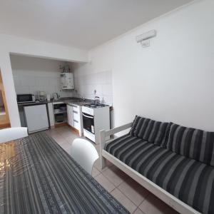 a living room with a couch and a kitchen at Cabañas Pailalen-Planta baja in Esquel