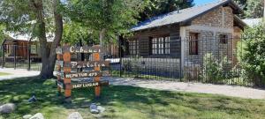 a sign in front of a house with a building at Cabañas Pailalen-Planta baja in Esquel