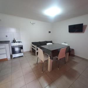 a kitchen with a table and chairs and a stove at Cabañas Pailalen-Planta baja in Esquel