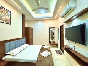 a bedroom with a bed with a flat screen tv at Surya Vilas Palace in Ujjain