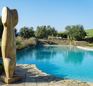 a statue in front of a swimming pool at Relais Sant'Elena in Bibbona