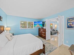 a blue bedroom with a bed and a living room at Beach Bungalow I Walk to Private Beach I Swimspa I Jacuzzi in Fort Lauderdale +24 photos