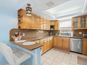 a kitchen with wooden cabinets and a counter top at Beach Bungalow I Walk to Private Beach I Swimspa I Jacuzzi in Fort Lauderdale
