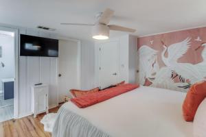 Un dormitorio con una cama blanca y un ventilador de techo. en The Cabana on the Coast, en Gulfport