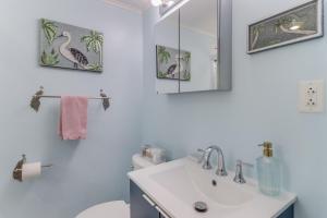 Un baño con lavabo, inodoro y espejo. en The Cabana on the Coast, en Gulfport 21 fotos más