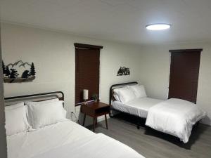 een slaapkamer met twee bedden en een tafel met een nachtkastje bij Cookson Resort - Tenkiller Cabin 2 in Cookson