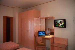 een kamer met een bureau, een laptop en een televisie bij Hotel Lanterna in Porto San Giorgio