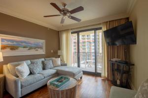 Una sala de estar con un sofá y un televisor de pantalla plana. en Two-Bedroom Harborwalk Village Vacation Rental, en Destin
