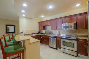 Una cocina con gabinetes de madera y encimera. en Two-Bedroom Harborwalk Village Vacation Rental, en Destin