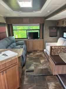 an rv living room with a couch and a tv at The Revere at Douglas Lake- Camper on the Lake in Sevierville