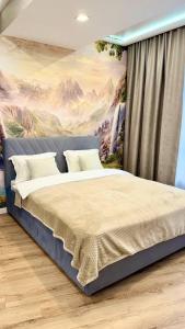 een slaapkamer met een bed met een schilderij aan de muur bij Seven Hills in Alma-Ata